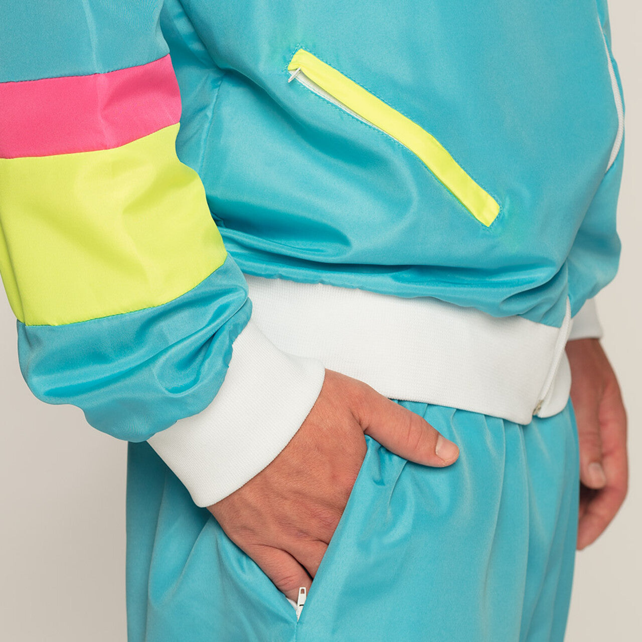 Op deze afbeelding zie je een Kostuums, van het merk Boland. Trainingspak Retro Dude Neonblauw Man Kostuum